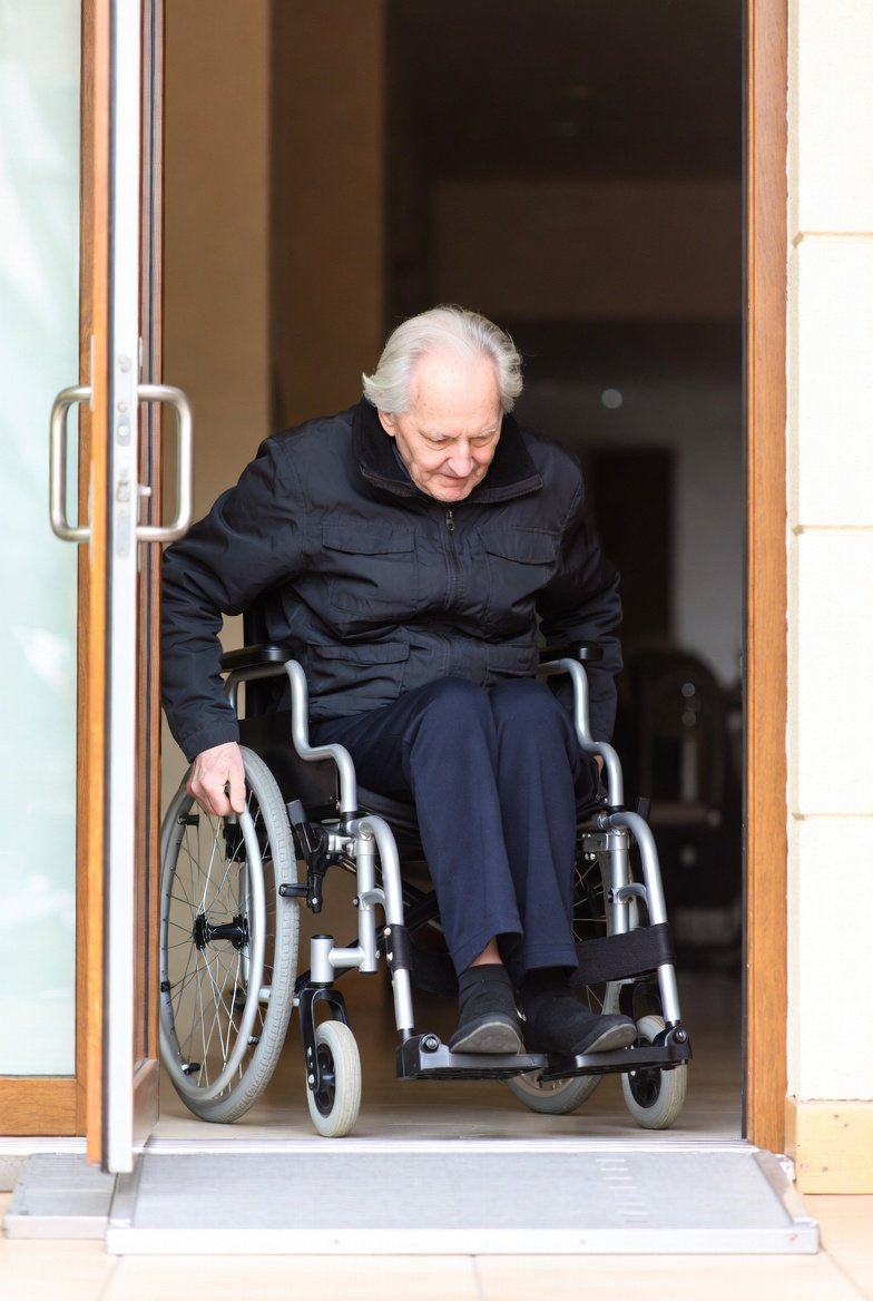 Folding lightweight wheelchair being lifted into a car trunk (show carry reality)